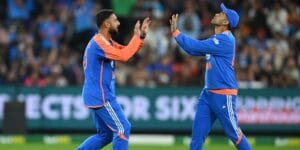 Varun Chakravarthy celebrates with a teammate after taking a wicket