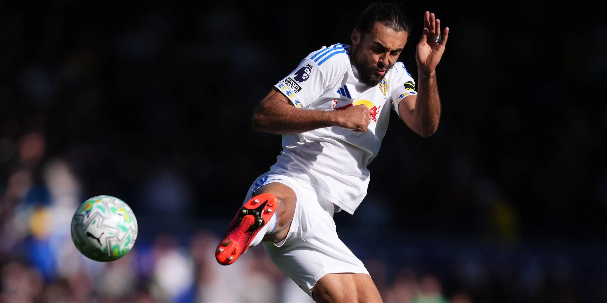 Dominic Calvert-Lewin jumping to kick a football for Leeds United