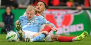 Erling Haaland wrestles for possession with Arsenal's William Saliba