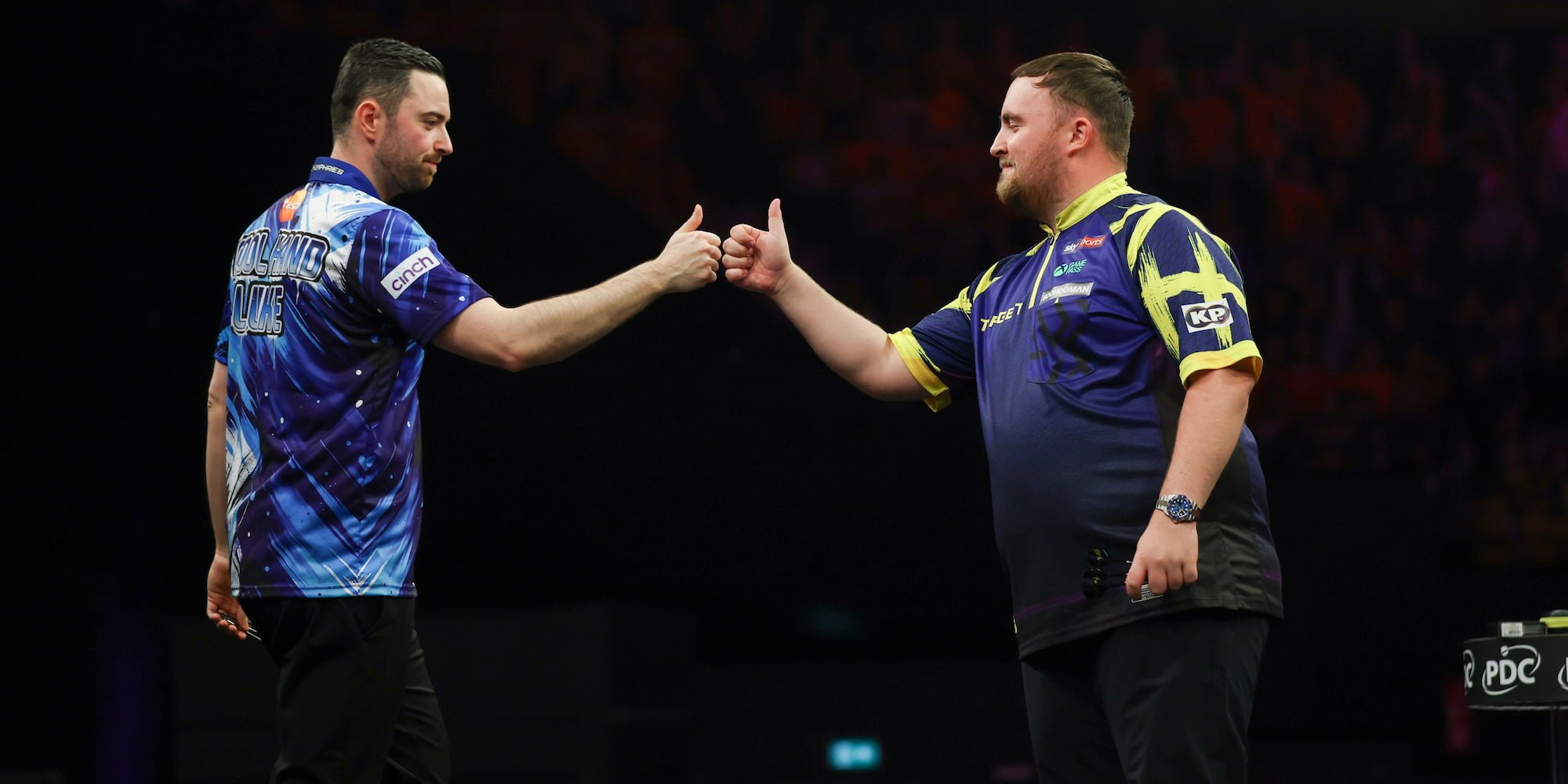 Luke Humphries and Luke Littler fist bump each other on stage in the Darts Premier League