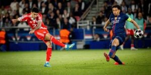 Luis Diaz for Bayern Munich kicks the ball with Marquinos of PSG trying to tackle him