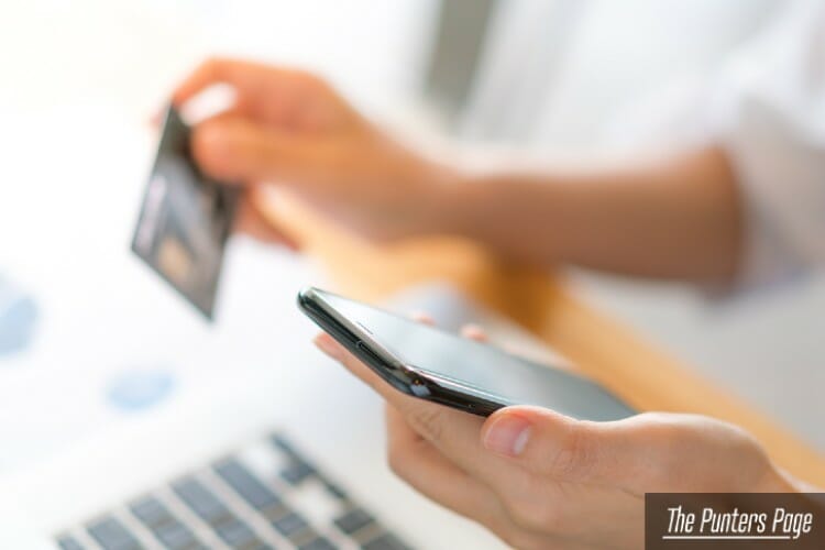 Hands holding a credit card using laptop computer and mobile phone for online shopping
